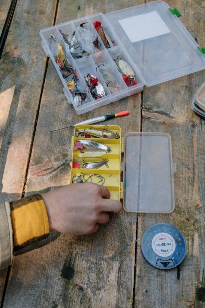 A collection of fishing lures and equipment neatly organized on a rustic wooden surface.